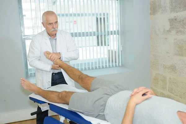 Fysiotherapeut masseren van voeten voor client — Stockfoto