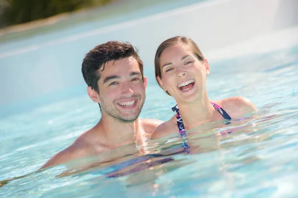 Gelukkig vakantiegangers in het zwembad — Stockfoto