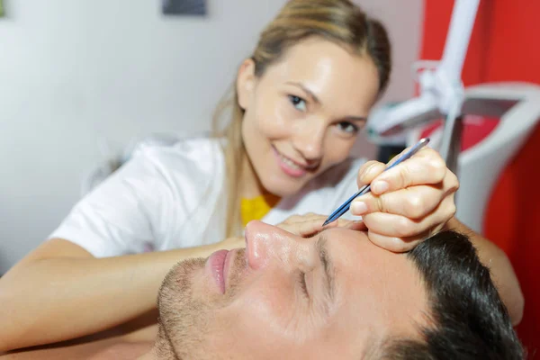 Esteticista haciendo masaje facial en salón de spa —  Fotos de Stock