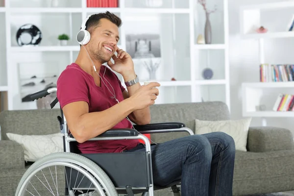 Man gelukkig in een rolstoel die luisteren naar muziek — Stockfoto