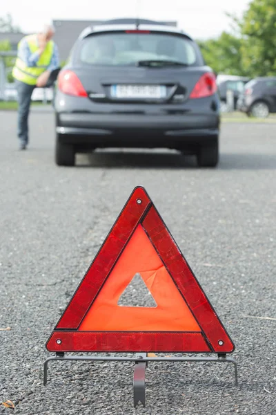 Triángulo de advertencia detrás del coche parado — Foto de Stock