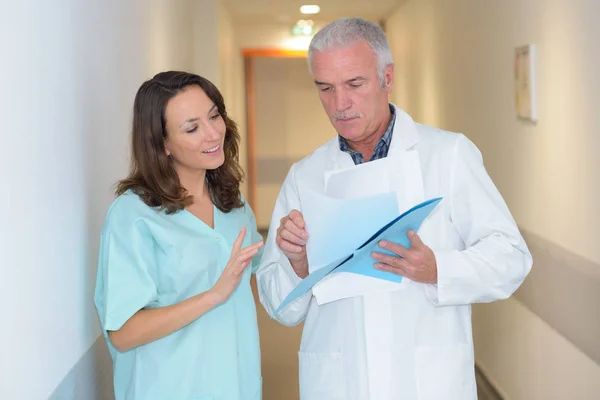 Intern and doctor on the hallway — Stock Photo, Image