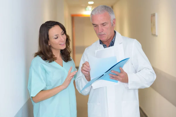 Estagiário e médico no corredor — Fotografia de Stock