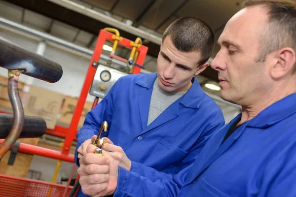 Homem explicando equipamento para estagiário — Fotografia de Stock