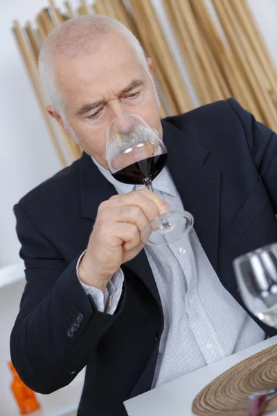 Homem mais velho cheiro de vinho tinto — Fotografia de Stock