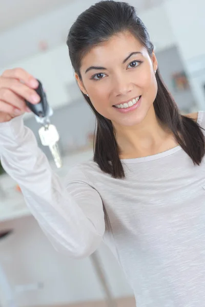 Happy female in casual holding appartment keys indoor — Stock Photo, Image