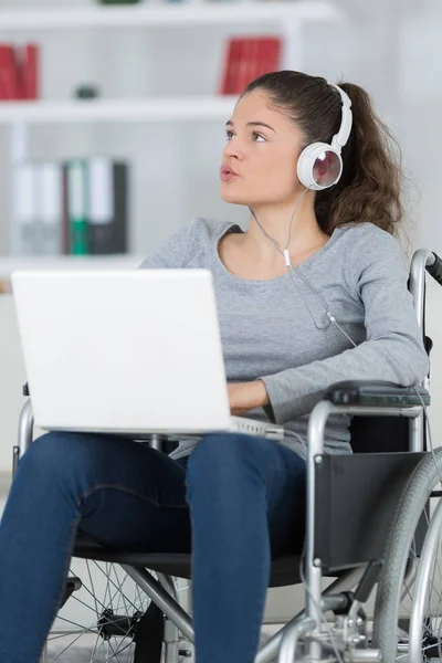 Mulher deficiente em cadeira de rodas com laptop — Fotografia de Stock