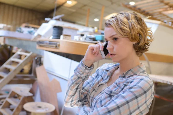 Mujer joven en el teléfono en taller marino —  Fotos de Stock