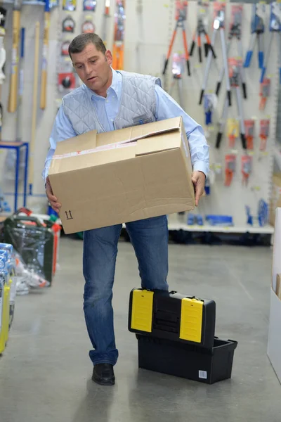 Porter bära lådor i ett lager — Stockfoto
