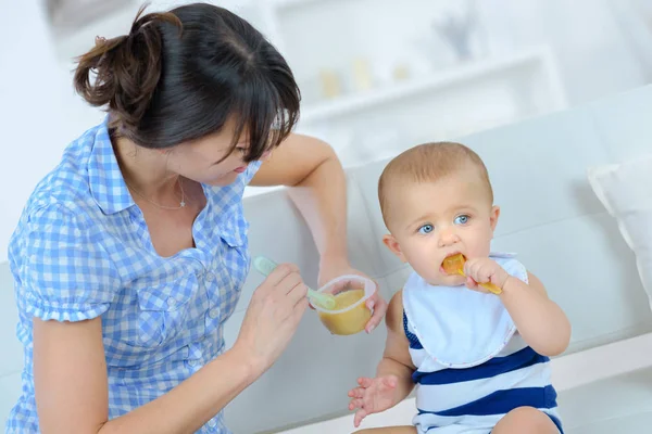 Mãe alimentando criança e refeição — Fotografia de Stock