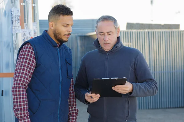 Gente de negocios leyendo en el portapapeles — Foto de Stock