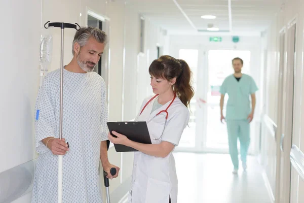 Krankenschwester schreibt Krankenakte im Krankenhausflur — Stockfoto