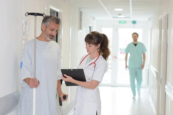 Infermiera che scrive una cartella clinica nel corridoio dell'ospedale — Foto Stock