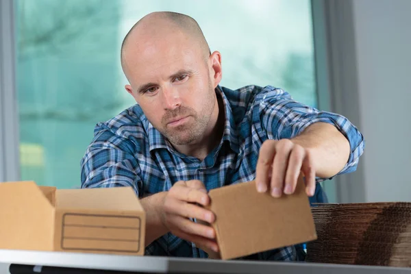 Repartidor hombre preparación cartones pequeños — Foto de Stock