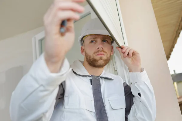 young contractor installing window blinds