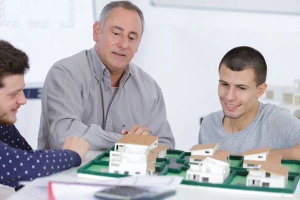 Architects looking at model housing development — Stock Photo, Image