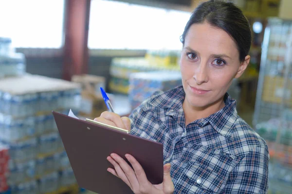 Lavoratrice che controlla il lavoro nei magazzini — Foto Stock