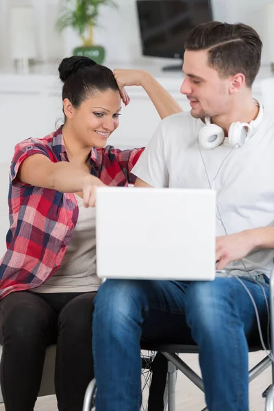 Behinderter Mann schaut mit Freundin Film auf Laptop — Stockfoto