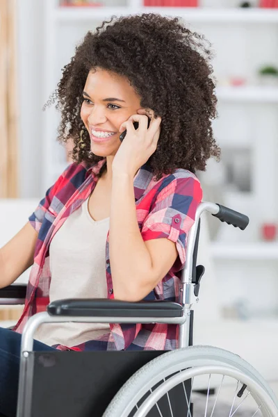 Handikappad kvinna på rullstolen med en mobil telefon — Stockfoto