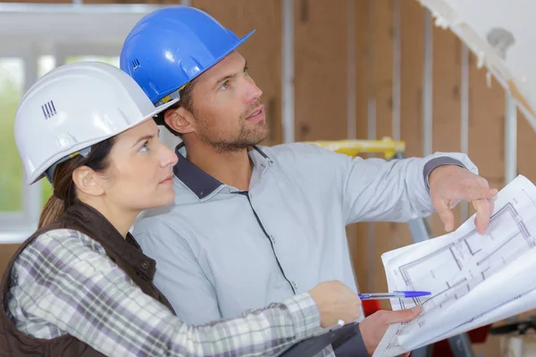 Arquitectos ingenieros discuten proyecto en obra — Foto de Stock