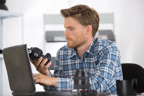 Técnico segurando componente e usando laptop — Fotografia de Stock