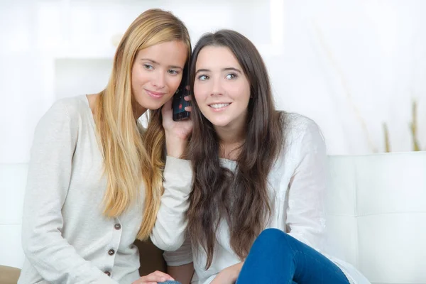 Duas jovens amigas felizes ouvindo conversa — Fotografia de Stock