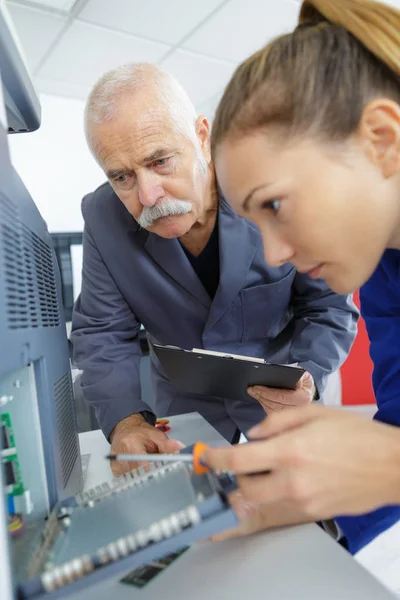 Kvinnliga appprentice reparera en dator hårddisk — Stockfoto