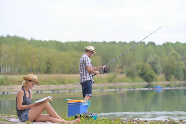 Fiatal pár halászatot a tó partján — Stock Fotó