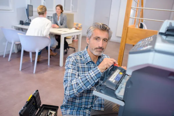 Чоловік ремонтує офісне фотокопіювання — стокове фото