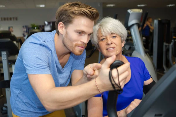 Coach showing the old woman her exercise result — Stock Photo, Image