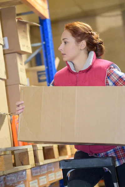 Magazijn werknemer nemen pakket in de winkelrekken in magazijn — Stockfoto