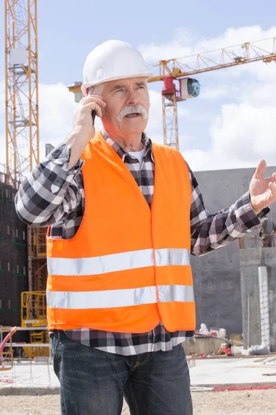 Travailleur manuel supérieur appelant au téléphone — Photo