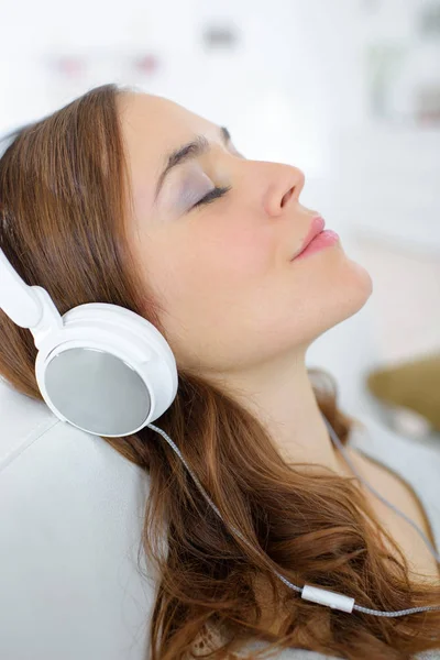 Visão de perfil da mulher ouvindo fones de ouvido — Fotografia de Stock