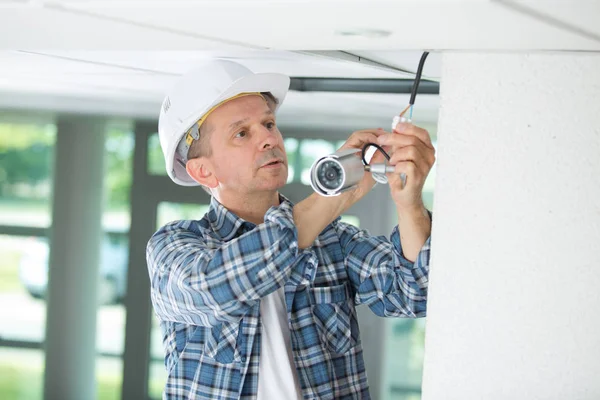 Maschio lavoratore ispezionare telecamera di sicurezza — Foto Stock