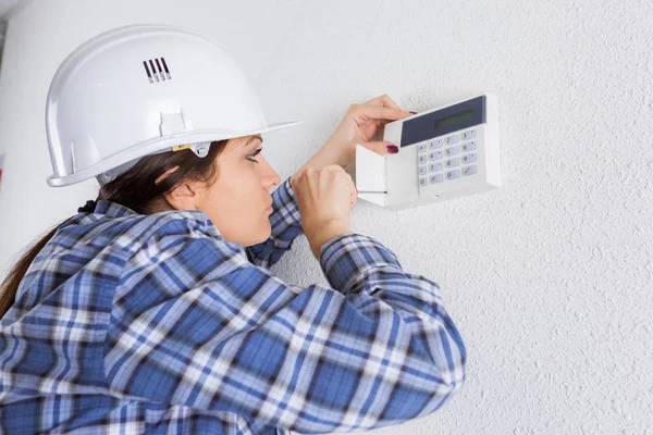 Bauunternehmer befestigt Tastatur an Wand — Stockfoto