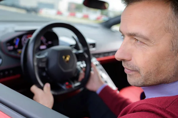 Gutaussehender Mann mittleren Alters am Steuer eines Autos — Stockfoto