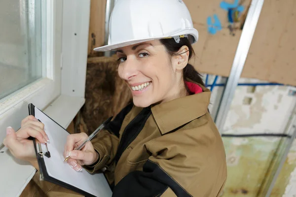 Chica arquitecta sonriente con portapapeles — Foto de Stock