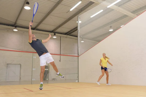 Vänner som spelar tennis spel indoori i tennisbana — Stockfoto