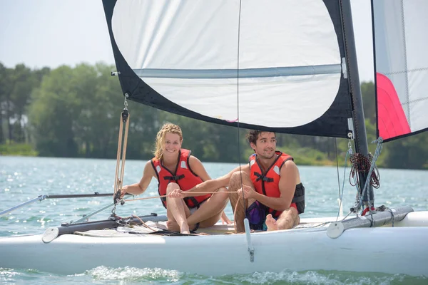 Una coppia seduta su una barca a vela — Foto Stock