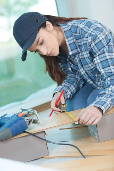 Empreiteira feminina que mede o piso — Fotografia de Stock