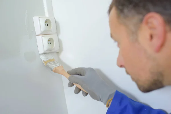 Vista trasera de un joven macho pintando una pared — Foto de Stock