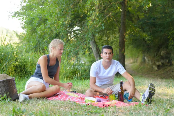 Young beautiful couplelying on the lawn in summer park — Stock Photo, Image