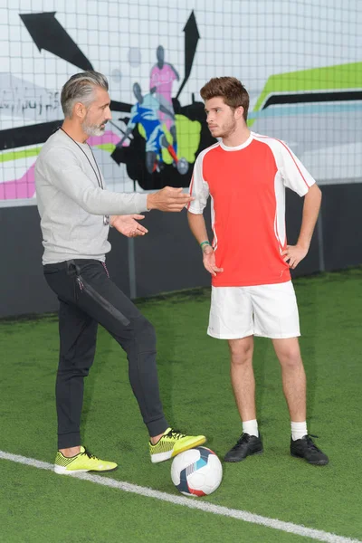 Voetbalspeler op het veld met coach — Stockfoto