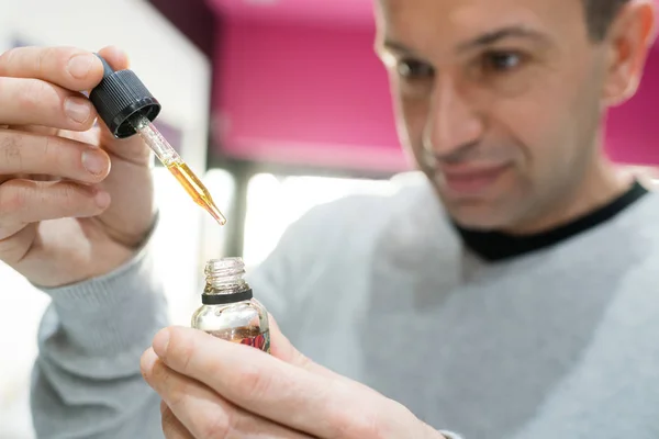 Jeune homme remplissant une cigarette électronique — Photo