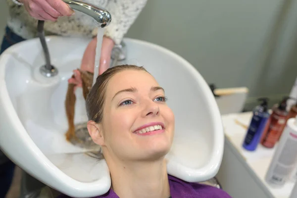 Mujer disfrutando de tener el pelo lavado en el salón — Foto de Stock