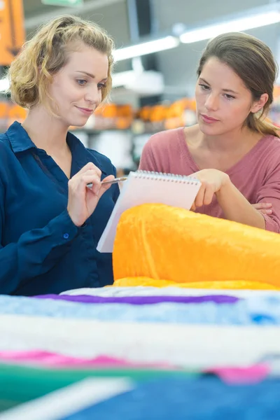 Mujeres elige tejido en la tienda — Foto de Stock