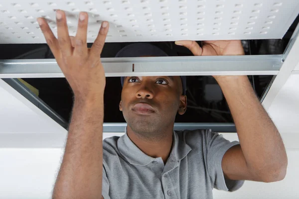 Man installs suspended ceiling in house — Stock Photo, Image