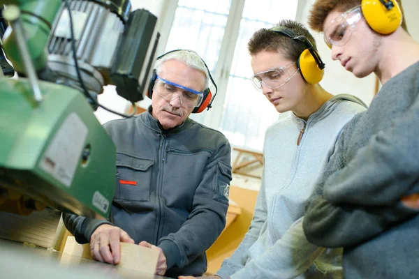 Carpintero demostrando máquina a los estudiantes —  Fotos de Stock