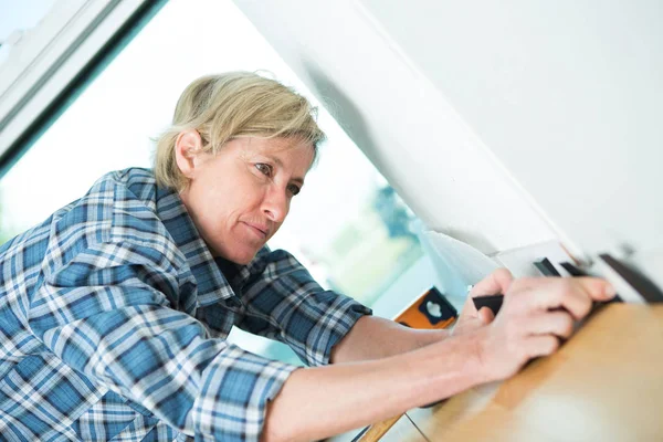 Mulher pressionando piso laminado — Fotografia de Stock