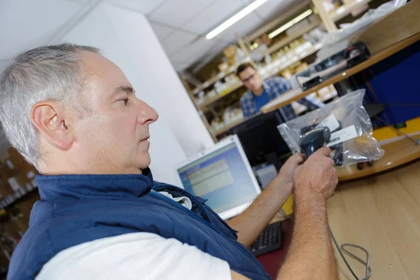 Человек, работающий за столом на складе сканирования штрих-кода — стоковое фото